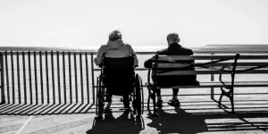 two elderly people sitting on a bench